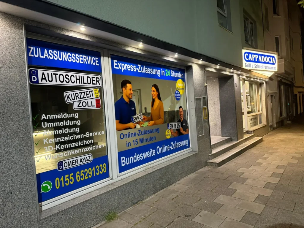 Beleuchtete Ladenfront von RUHR KFZ am Abend, von der Seite gesehen